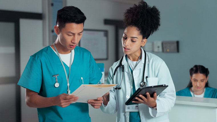 nurse and dnp talking at nurses' station