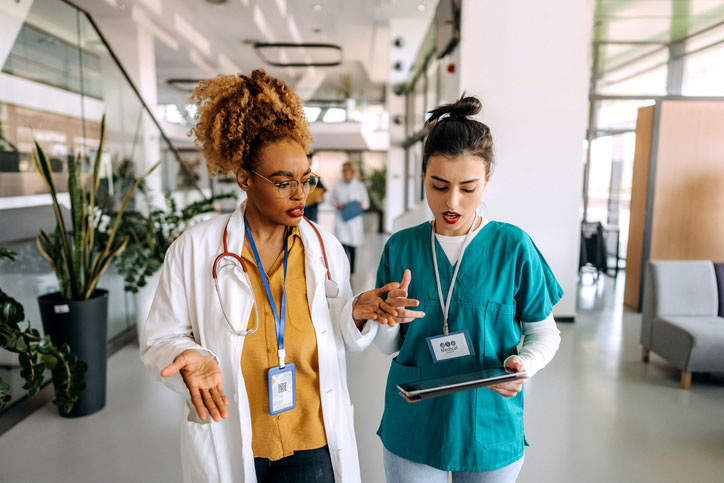 two fnp's walking and talking in hospital hall