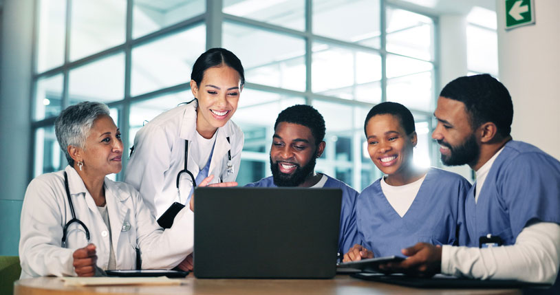 group of medical professionals smiling behind the computer